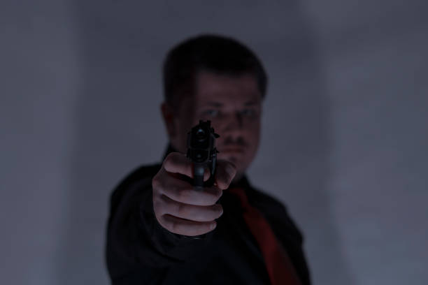 istock Robber with a gun in a dark room. A crime. 904925680