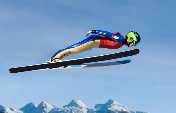 Side view of young  female ski jumper in mid-air