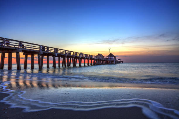 naples pier am strand bei sonnenuntergang - naples stock-fotos und bilder