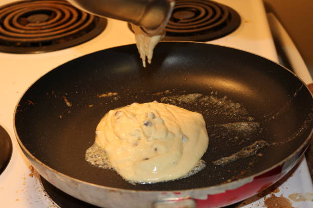 istock Pancake dough being added into a frying pan. This is the final step of making pancakes 904932552