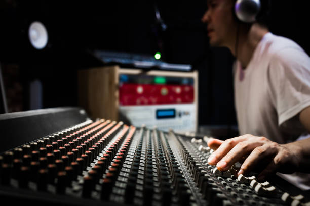 asiatische männliche dj, tontechniker und musikproduzent arbeitet an sound-mixer in aufnahme, rundfunk studio. hände im fokus - radiomoderator stock-fotos und bilder