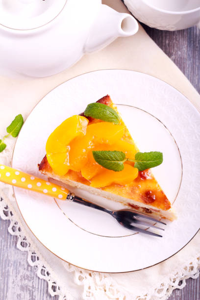 istock Slice of cheesecake with peach on top, on plate 904947856