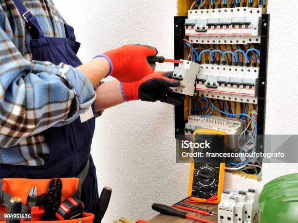 Young Electrician Technician At Work On A Electrical Panel With Protective Gloves Stock Photo - Download Image Now