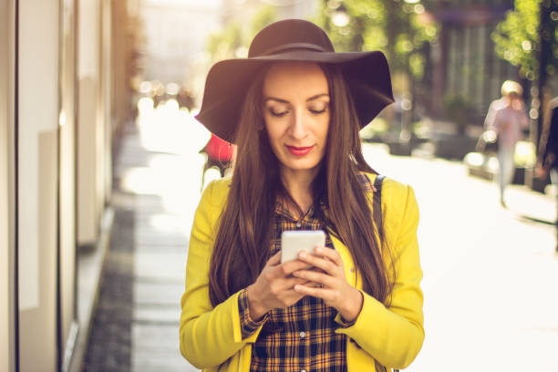 istock beautiful woman using phone on the street 904951838