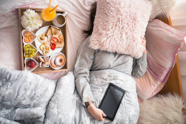 istock Charming female texting on her tablet after waking up 904957984