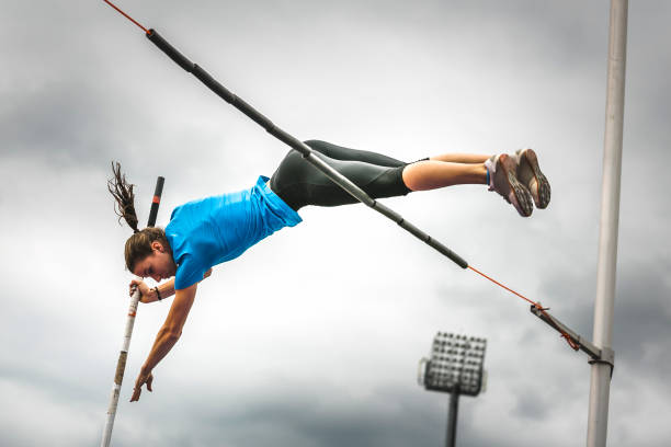 Female athlete successful attempt bar clearance stock photo
