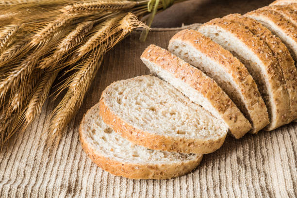 istock Fresh sliced bran bread on the kitchen towel on the table. Rustic atmosphere. Healthy eating and lifestyle. Food background. 904961992