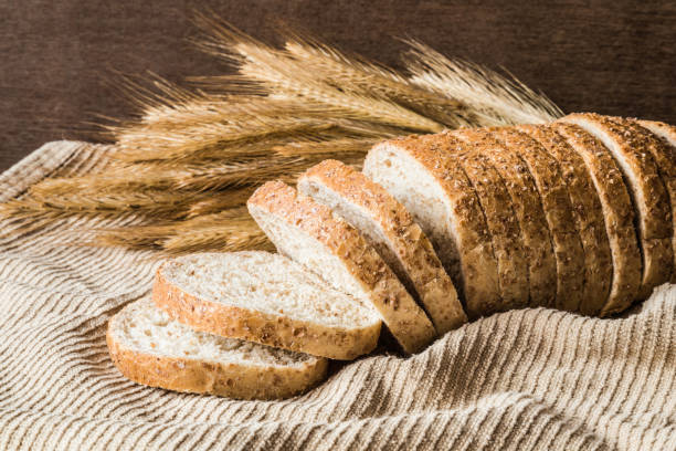 istock Fresh sliced bran bread on the kitchen towel on the table. Rustic atmosphere. Healthy eating and lifestyle. Food background. 904964092