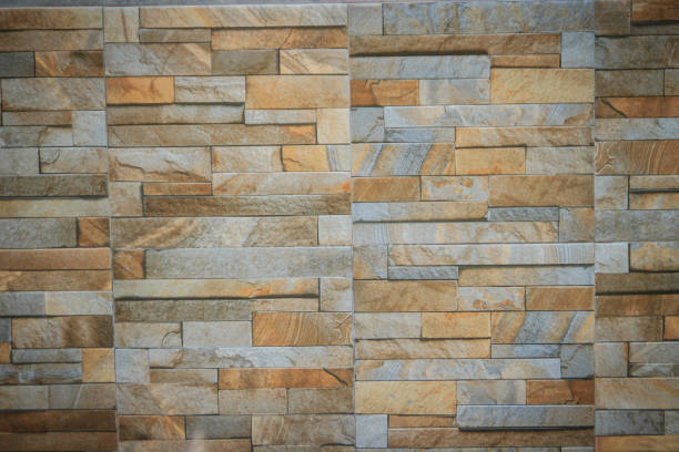 istock Wall tiles patterned like natural split stone background. Simulated yellow natural stone facade, wall tiles texture. 904971398