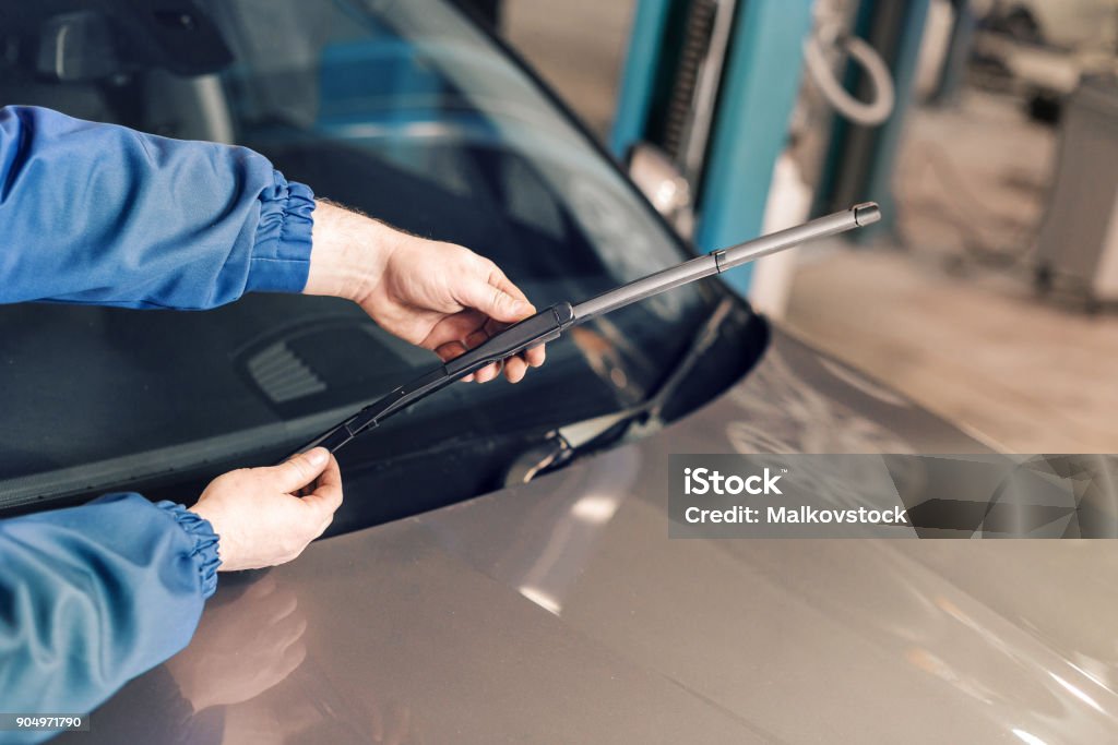 Technician is changing windscreen wipers on a car station. Technician is changing windscreen wipers on a car station Windshield Wiper Stock Photo