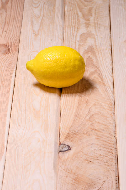 istock lemon isolated on wooden table 904975804