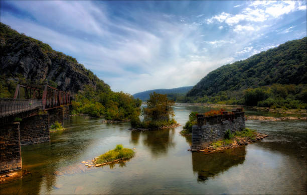 Where Rivers Meet The confluence of the Potomac and Shenandoah Rivers with a railroad bridge in the foreground. harpers ferry photos stock pictures, royalty-free photos & images