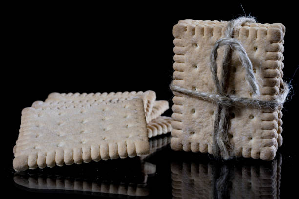istock Crumbly biscuits tied with a string on a glass table. Tasty cakes on a mirror table, black background 904990938