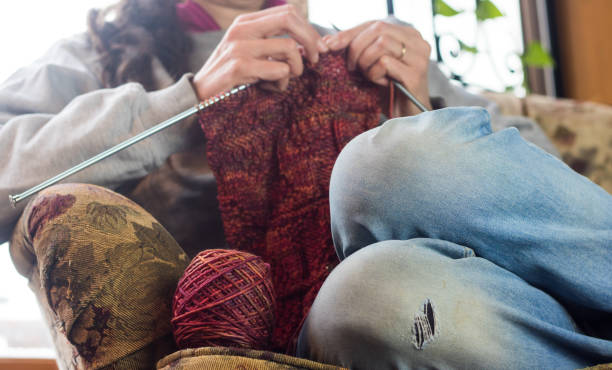 istock Woman knitting on an armchair 904997068