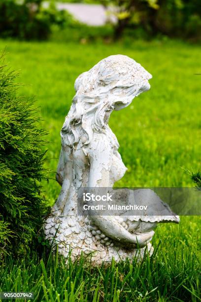 Old Statue Of A Seated Girl In A Park In The Grass Stock Photo - Download Image Now