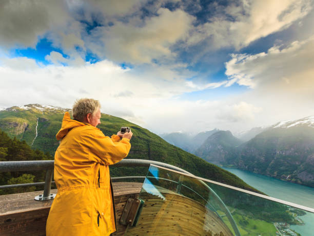 Tourist photographer with camera on Stegastein lookout, Norway Tourism and travel. Male tourist nature photographer taking photo with camera, enjoying Aurland fjord landscape from Stegastein lookout, Norway Scandinavia. stegastein viewpoint stock pictures, royalty-free photos & images