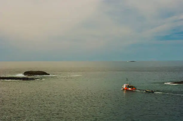 Photo of A troller leaving Fogo harbor for the high sea at sunset,