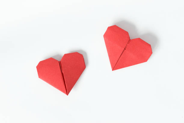 白い背景の上の 2 つの赤い折り紙の心。バレンタインの日ギフト カード。平面図です。 - valentines day origami romance love ストックフォトと画像