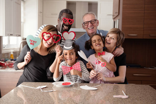istock Multi-Ethnic family doing photobooth during Valentine's day 905027938