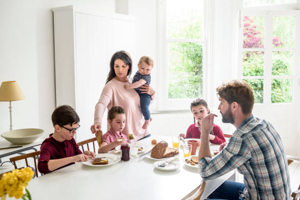 아침 식사, 어머니가 아기를 수행 하는 동안 아들 토스트를 봉사 하는 바쁜 가족 - family dining table breakfast eating 뉴스 사진 이미지