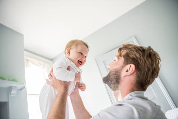 istock Cheerful baby being held by father, smiling 905028686