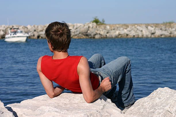 istock Young man laying on rocks at the shore 90504705