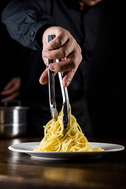 istock Italian pasta spaghetti food  being cooked and plated by chef 905054922