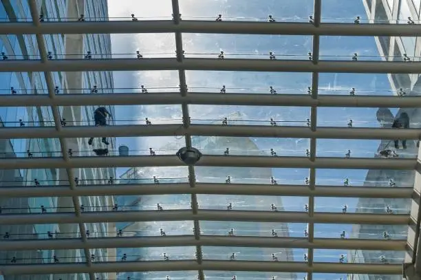 Two workers without fear of heights do a job considered high risk because it consists of cleaning the glass roof of a shopping center in Mexico City.