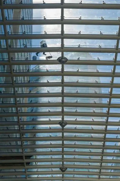 A worker without fear of heights does a job considered high risk because it consists of cleaning the glass roof of a shopping center in Mexico City.