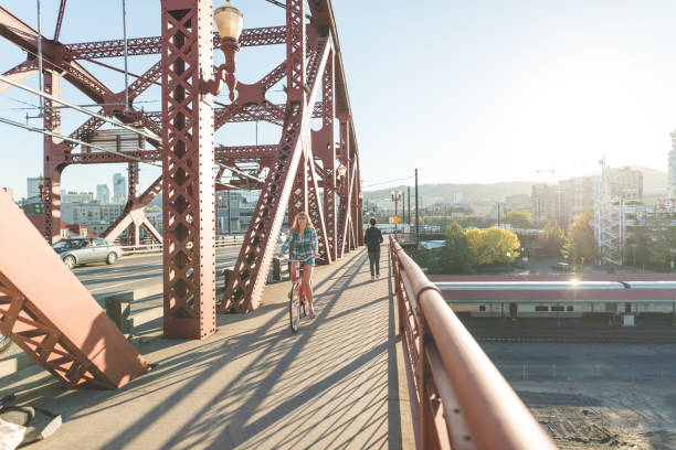 istock Woman Riding Bicycle Across City Bridge 905068400