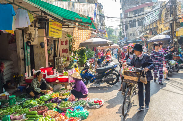 Busy local daily life of the morning street market in Hanoi, Vietnam. A busy crowd of sellers and buyers in the market. stock photo