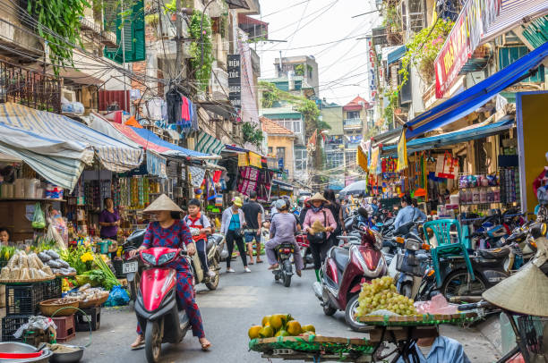 vida diária local ocupada do mercado de rua de manhã em hanói, no vietname. uma multidão ocupada de vendedores e compradores no mercado. - vietnam asia hanoi street - fotografias e filmes do acervo