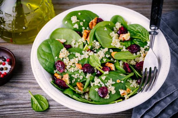 istock Green salad bowl with spinach, quinoa, walnuts and dried cranberries 905095592