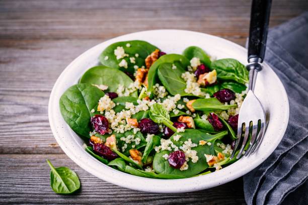 istock Green salad bowl with spinach, quinoa, walnuts and dried cranberries 905095614
