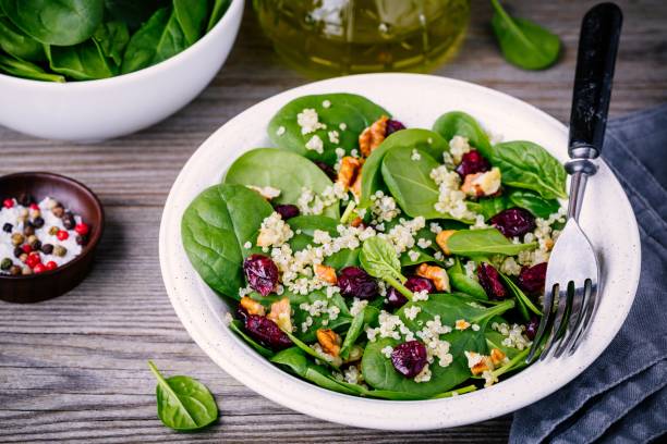 istock Green salad bowl with spinach, quinoa, walnuts and dried cranberries 905096012