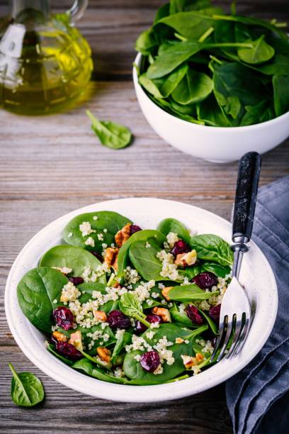 istock Green salad bowl with spinach, quinoa, walnuts and dried cranberries 905097776