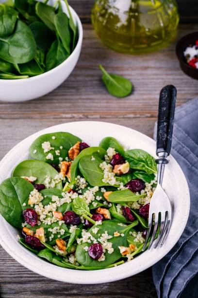 istock Green salad bowl with spinach, quinoa, walnuts and dried cranberries 905097804