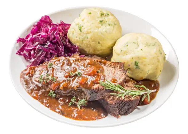 German stewed beef meat with red cabbage and potato dumpling, isolated. Sauerbraten