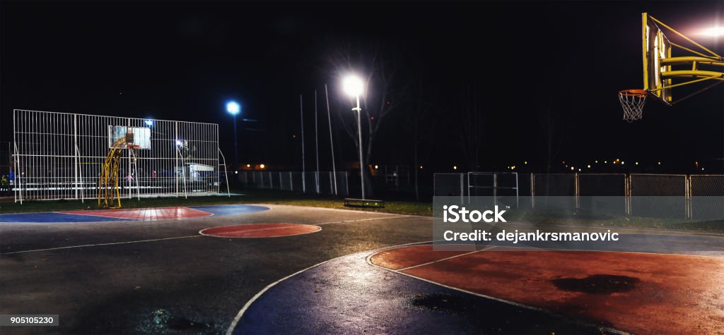 Basketball Court at Night Street basketball yard by night, outdoor scene. Agricultural Field Stock Photo