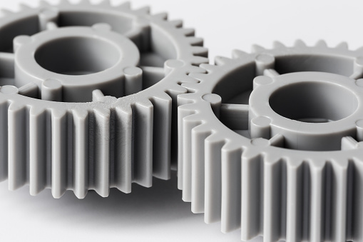 two plastic gears closeup geared for one another