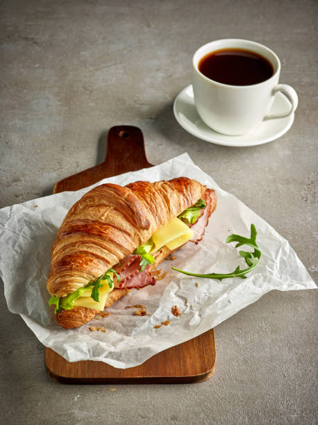 istock Croissant with ham and cheese on grey table 905105798