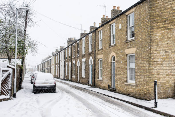 fileira de casas restauradas de britânicas períodas georgianas em tijolos amarelos durante a neve no inverno com o carro estacionado em frente na rua local coberta de neve. - period costume fotos - fotografias e filmes do acervo