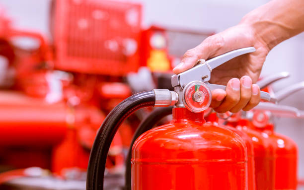 extintor de incendios y pasador tirando en el tanque rojo de cerca. - fire extinguisher office safety protection fotografías e imágenes de stock