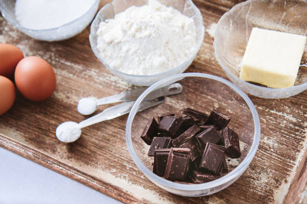 istock Baking ingredients for chocolate cake muffins or cookies lying ready on wooden kitchen tray 905122416
