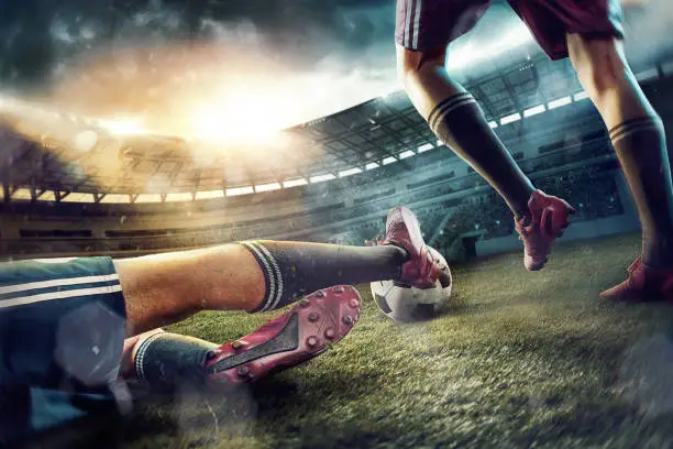 The legs of soccer football players on green field of the stadium. Advertising concept of soccer football