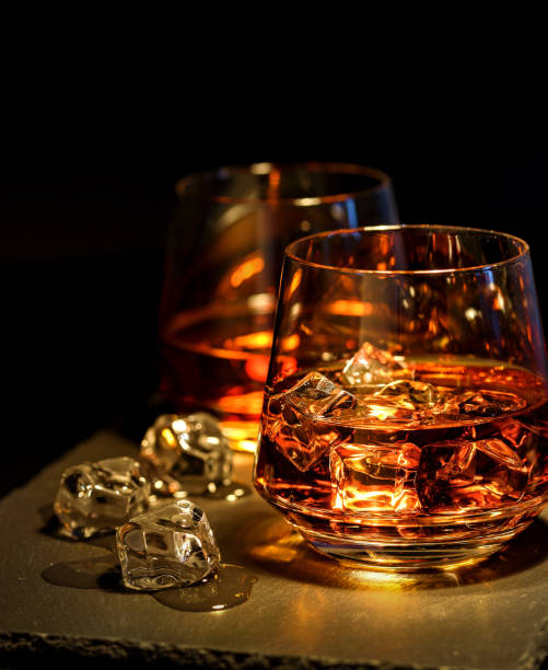 istock Two glasses of whiskey with ice on a black background 905122834