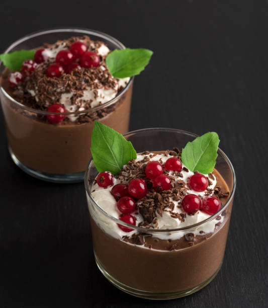 istock Chocolate mousse with currant and mint in a glasses on a black stone background. 905125460