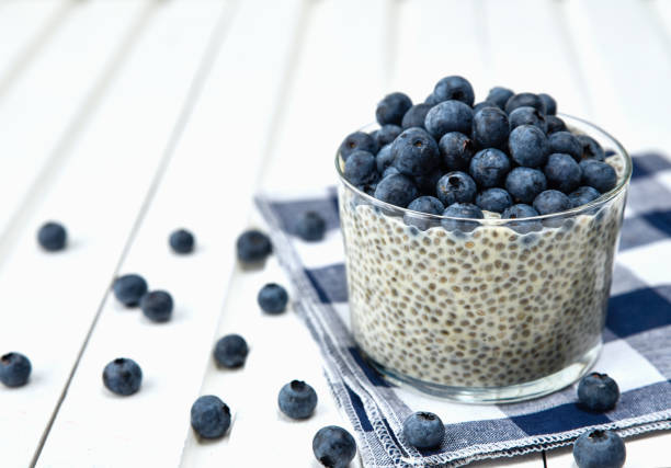 istock Chia pudding with blueberries on striped canvas, white wood background 905125552