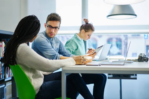 istock Group of young male and female architects talking about productive strategy for developing startup project sitting in office interior.Diversity students collaborating while searching information 905130430