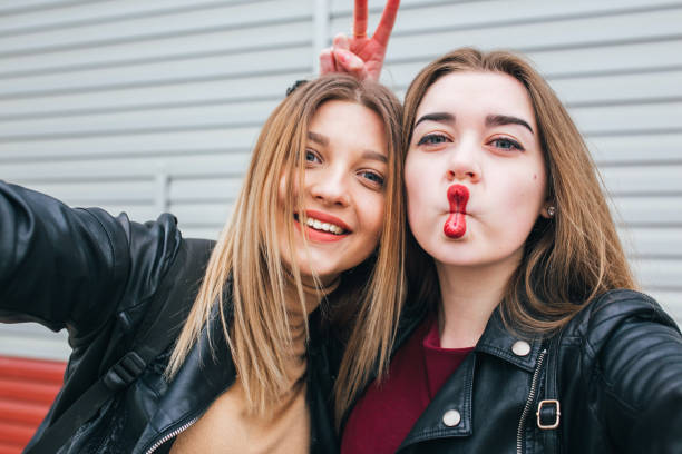 Two young girls taking selfie using smartphone